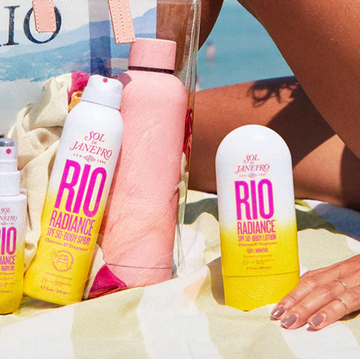 10 Best-Smelling Sunscreens for Summer 2024 a person's feet on a towel next to a couple of bottles