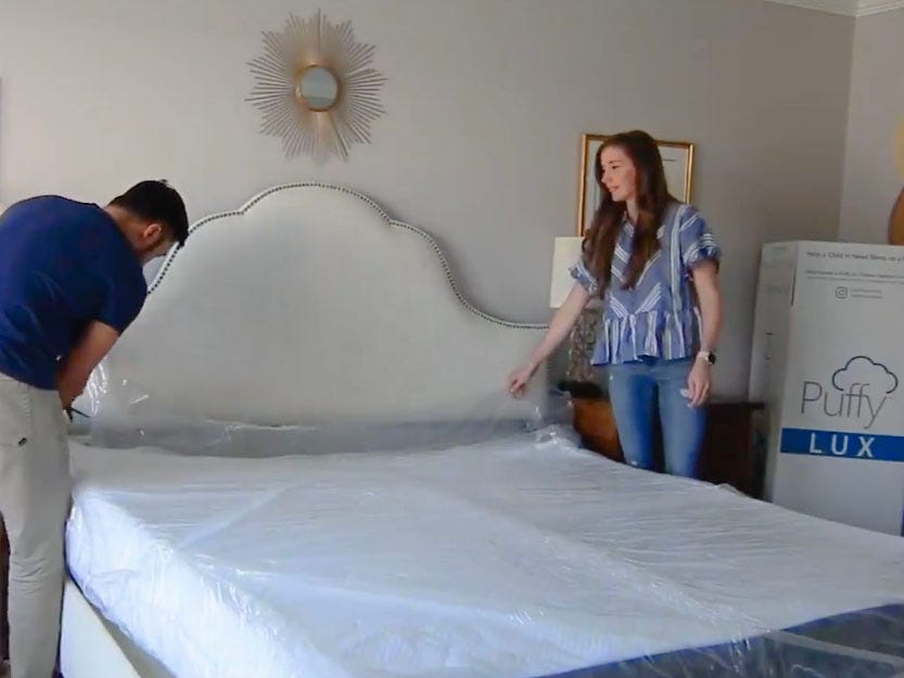 a man and woman opening a puffy mattress