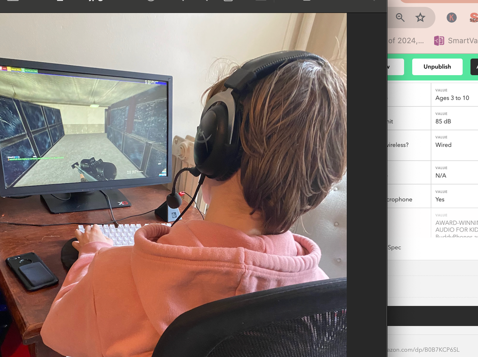 a boy wears headphones while playing a video game, part of a good housekeeping list of the best kid's headphones