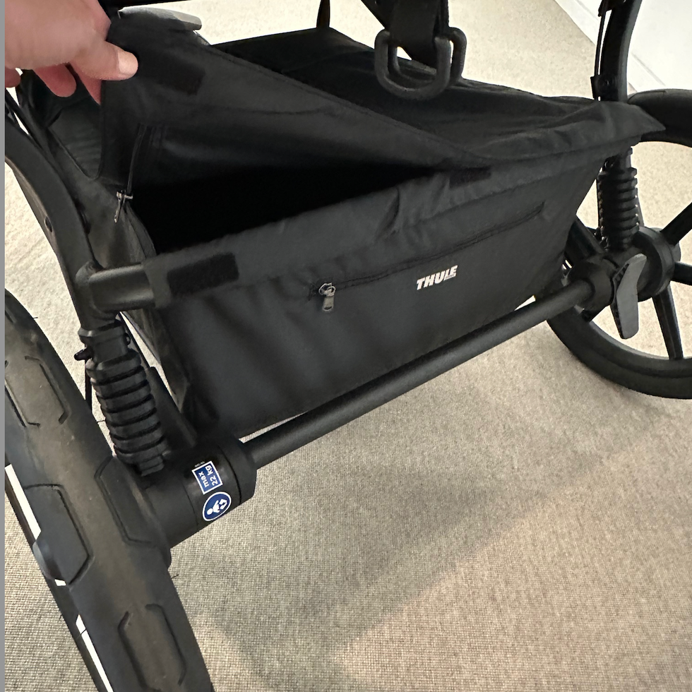 The Thule double stroller's basket has a zipper a good housekeeping institute stroller tester unzips the basket under the thule double stroller
