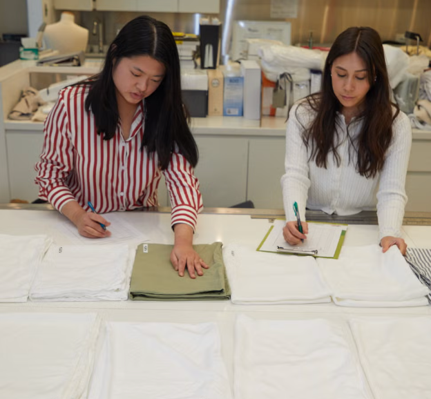 two gh analysts touching sheets and rating them for softness