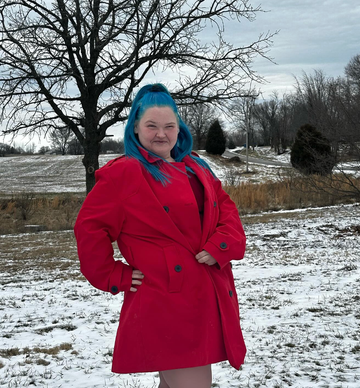 amy slaton smiles in a red coat with a snowy background