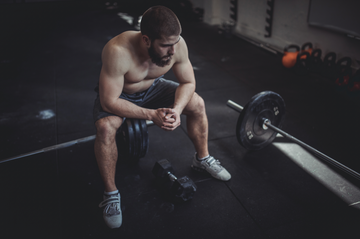 man sitting on bench in gym