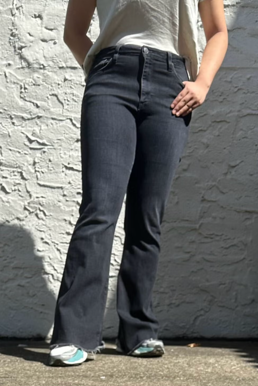a person from the waist down modeling jeans from hudson against a concrete wall