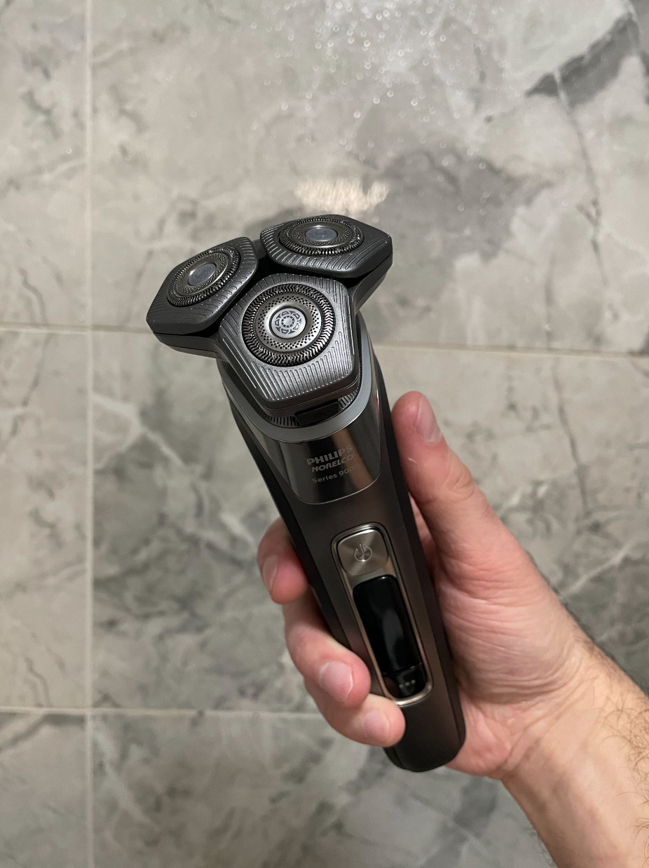 electric shaver with three circular heads held in a hand