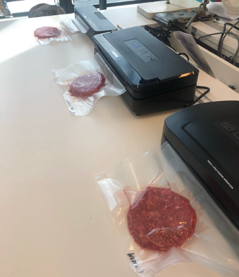 vacuumsealed packages of meat on a countertop next to vacuum sealing machines