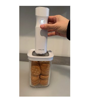 handheld device sealing a container of crackers