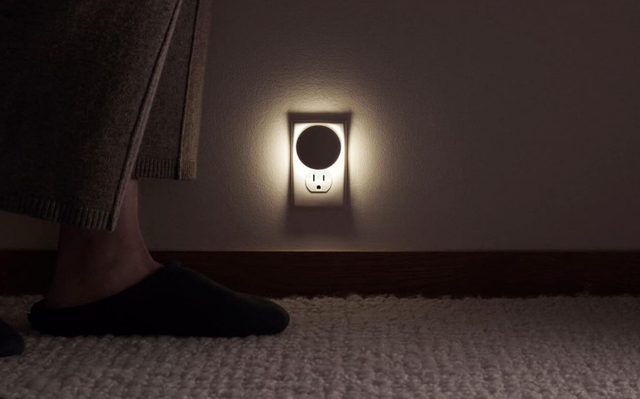 lowlight environment with a wall socket and a persons foot