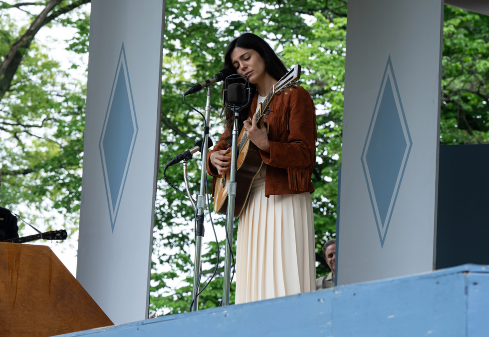 singer performing on stage with a guitar and microphone