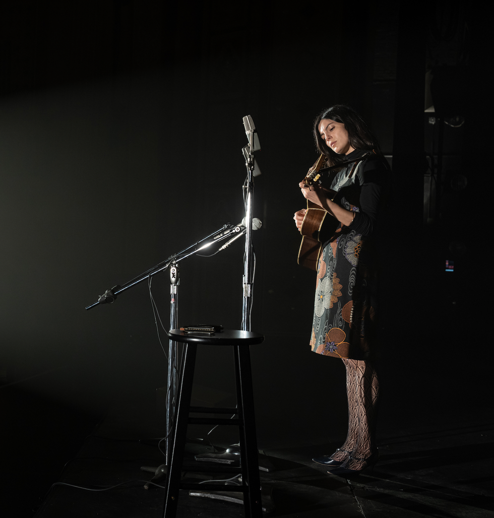 a musician performing on stage with a guitar and microphone setup