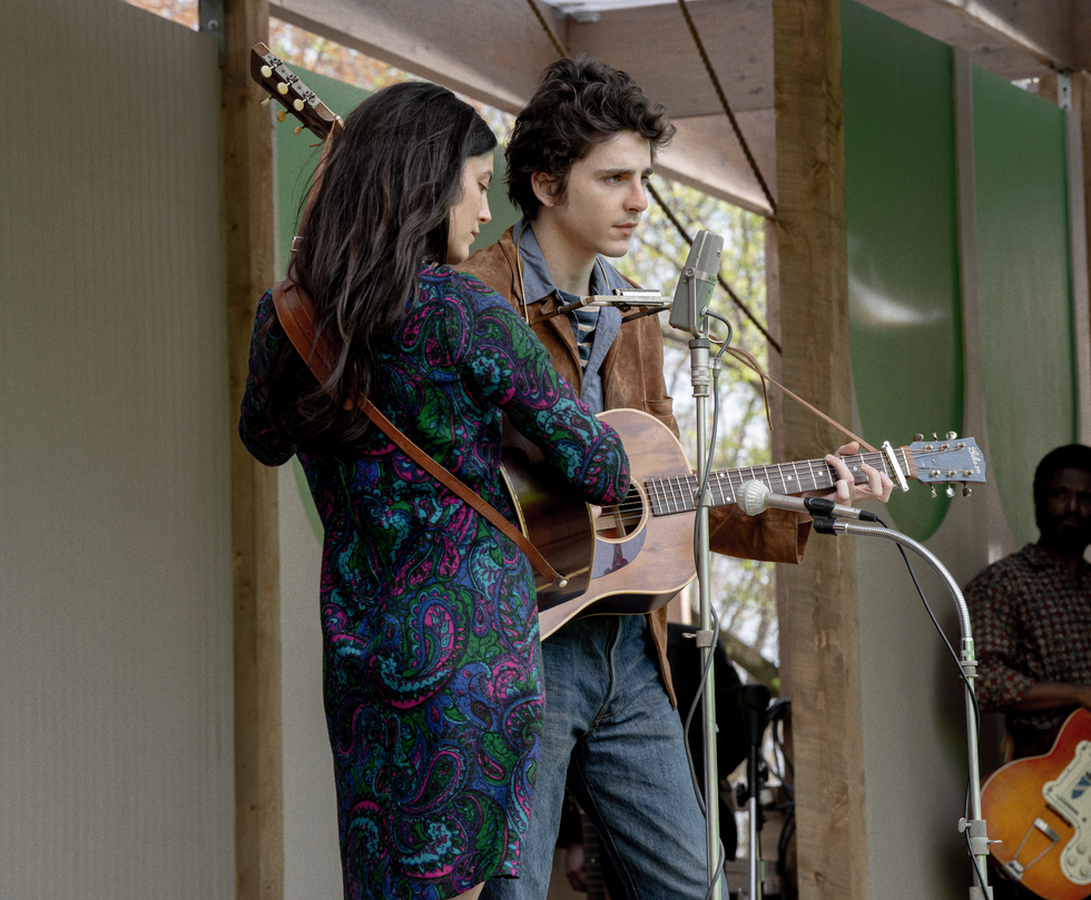 musicians performing on stage with guitars and microphones