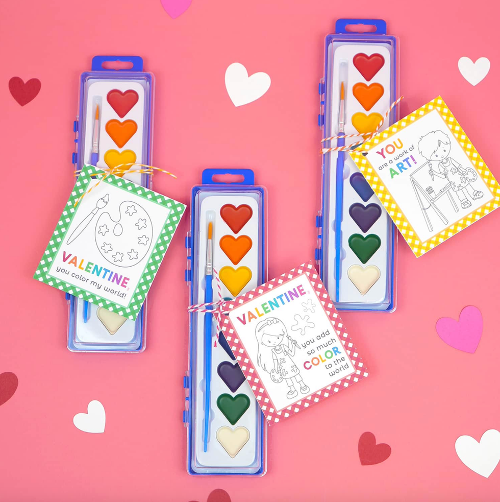 valentines day themed watercolor paint sets and greeting cards on a pink background