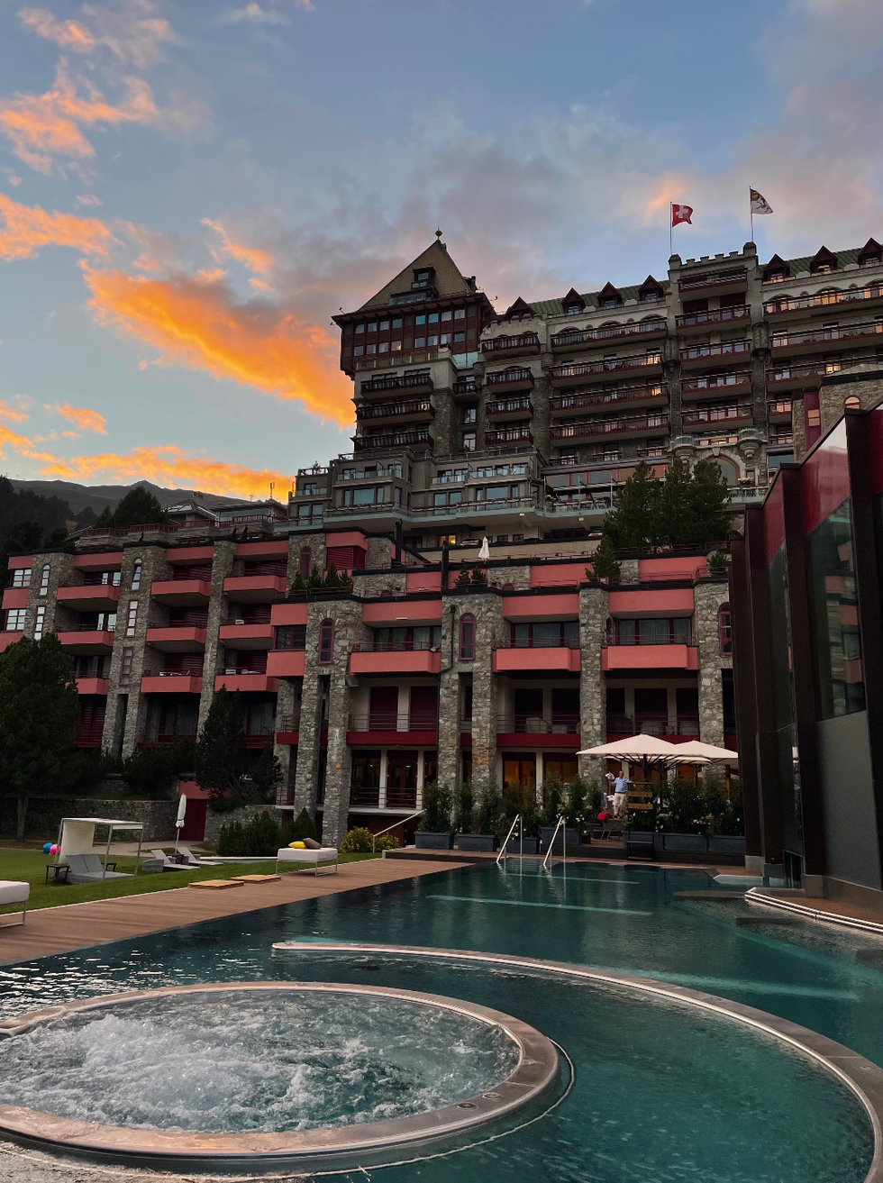 luxury hotel with outdoor swimming pool at sunset