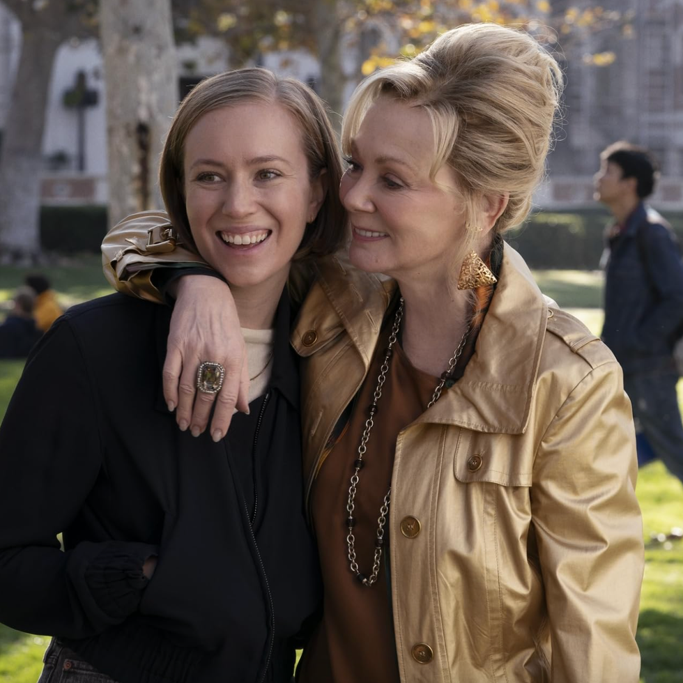 Hacks TV Series two women posing together in a park setting with background activity
