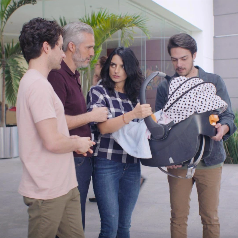 The House of Flowers a group of four individuals interacting while holding a baby carrier