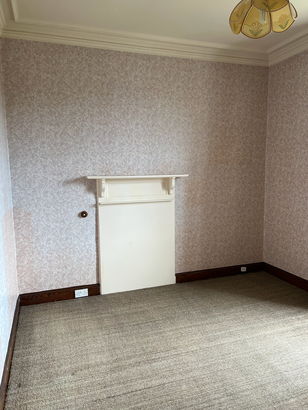 empty room with wallpaper and a ceiling light