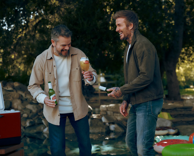 two men outdoors enjoying beverages during a social gathering