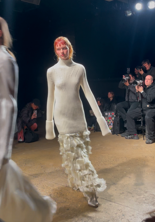 fashion model walking on runway showcasing a stylish outfit