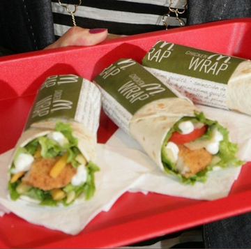 tray holding three chicken wraps with fresh ingredients tray holding three chicken wraps with fresh ingredients