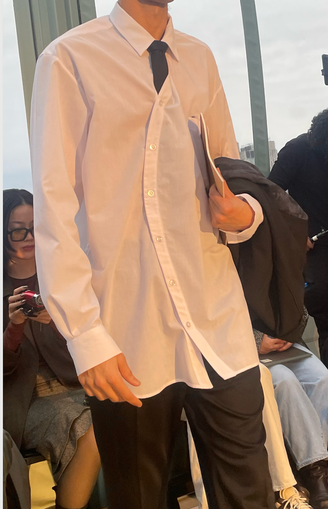 model showcasing a fashion outfit with an oversized white shirt and black pants