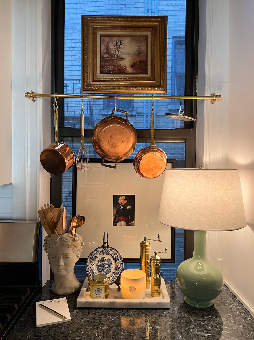 kitchen countertop with hanging copper pots and decorative items