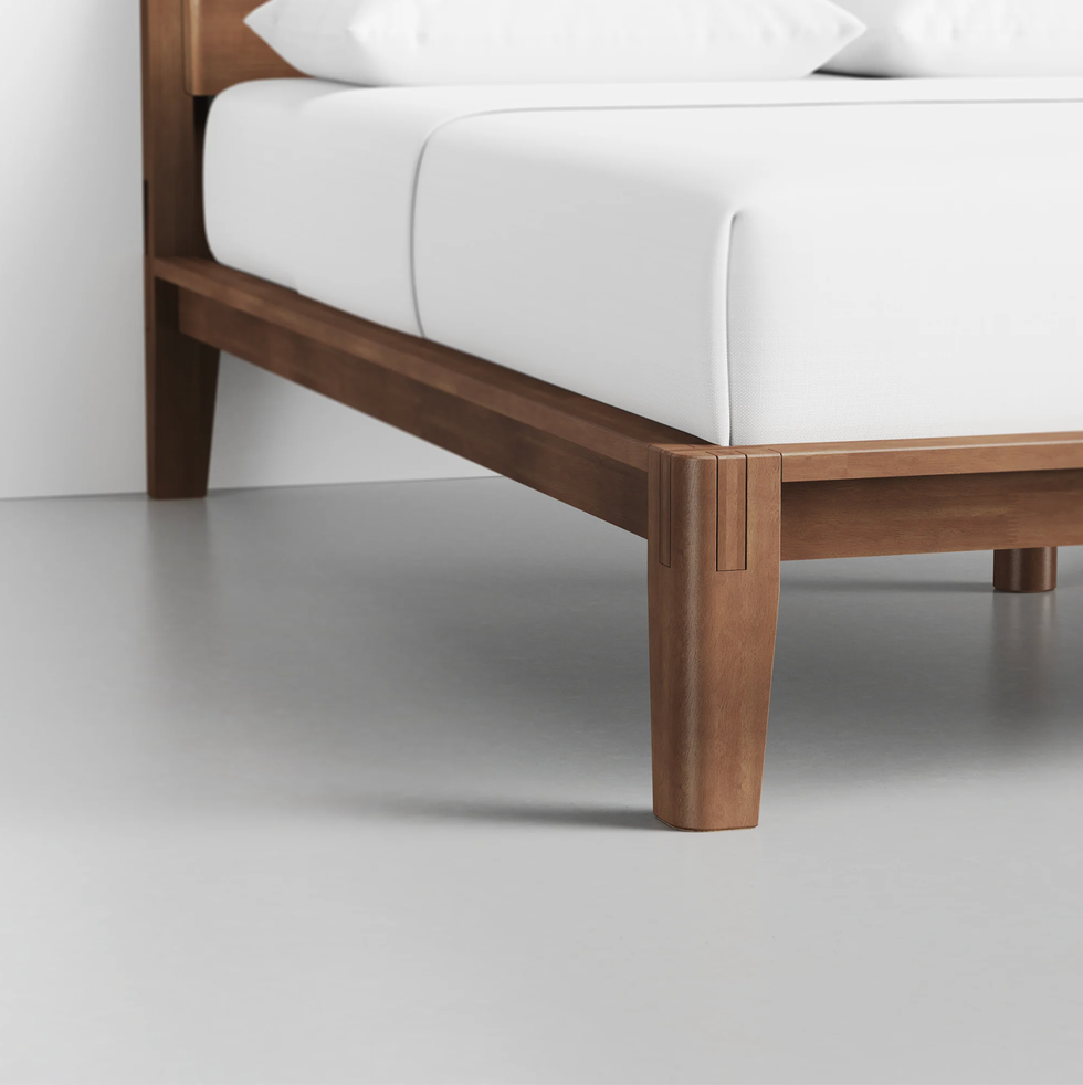wooden bed frame with a white mattress and pillows