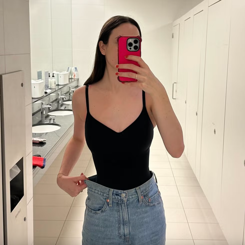 a person showcases a fashion outfit combination in a restroom