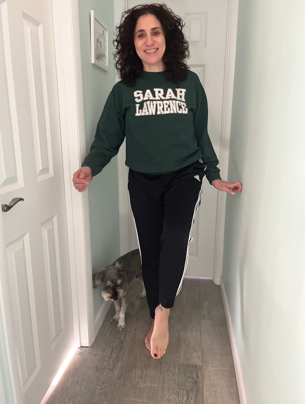 person walking in a narrow corridor with a dog beside them