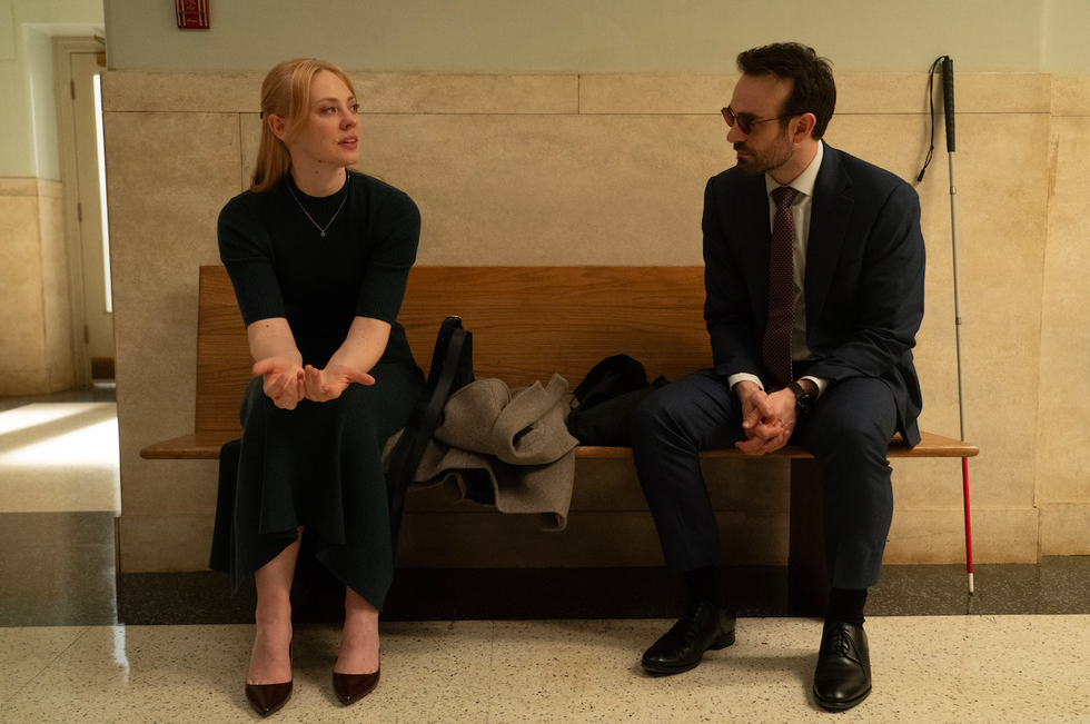 two people sitting on a bench chatting