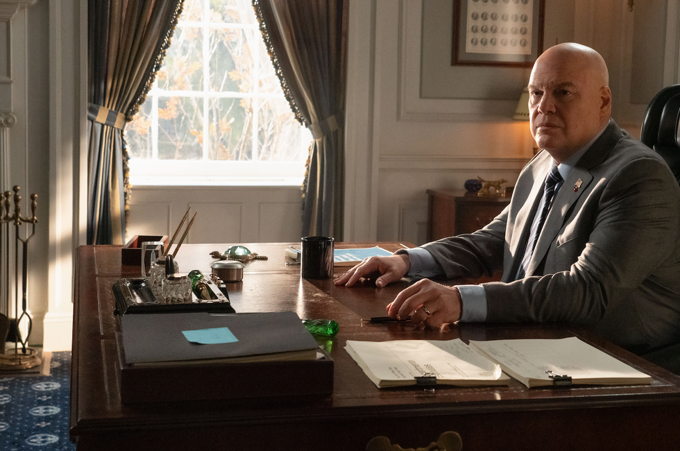 an office scene featuring a desk a person in formal attire and various items