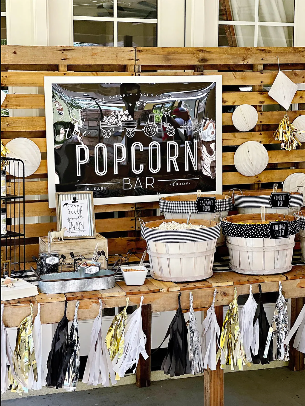 popcorn bar setup with various popcorn flavors and decorative elements