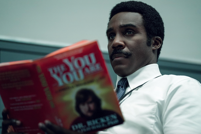 mr. milchick holding a book