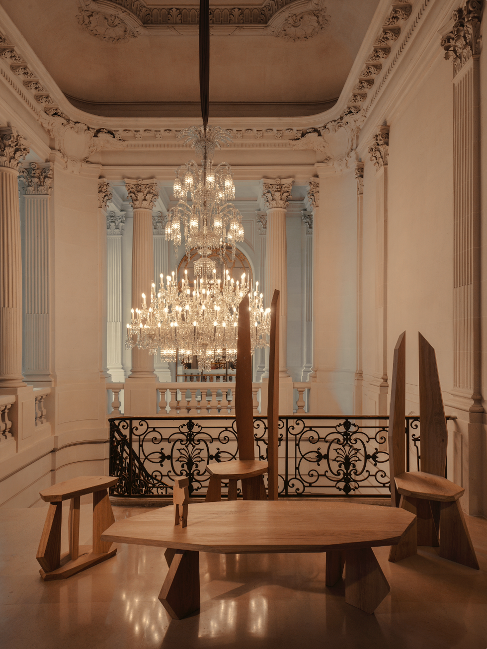 wooden furniture set in an ornate interior with a chandelier