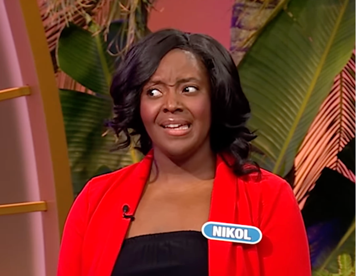 a person participating in a game show setting wearing a red outfit