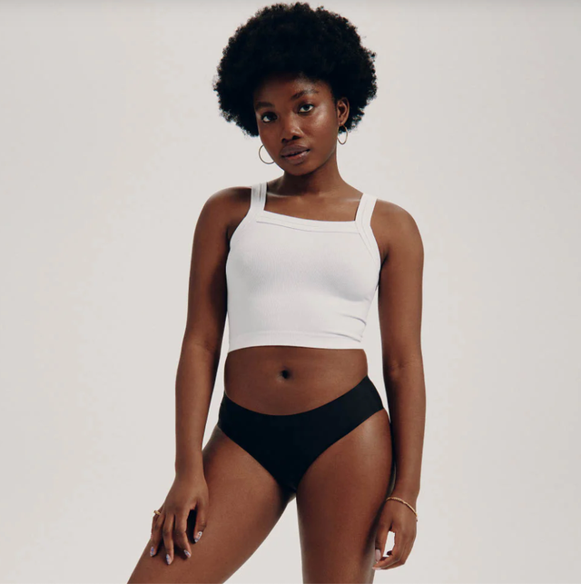knixteen review a woman wearing black period underwear from knixteen and a white tank