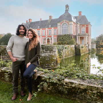 Couple posing in front of a historic building with a moat couple posing in front of a historic building with a moat