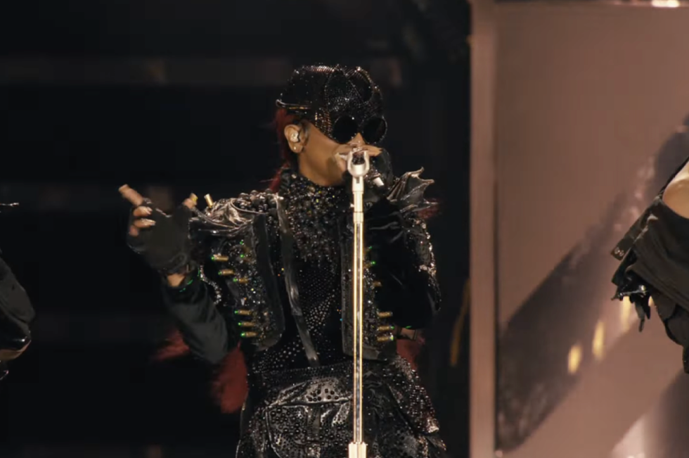 a performer in an elaborate costume singing on stage