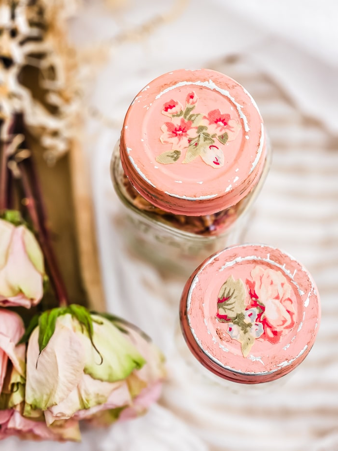 glass jars with floral lids and dried flowers nearby