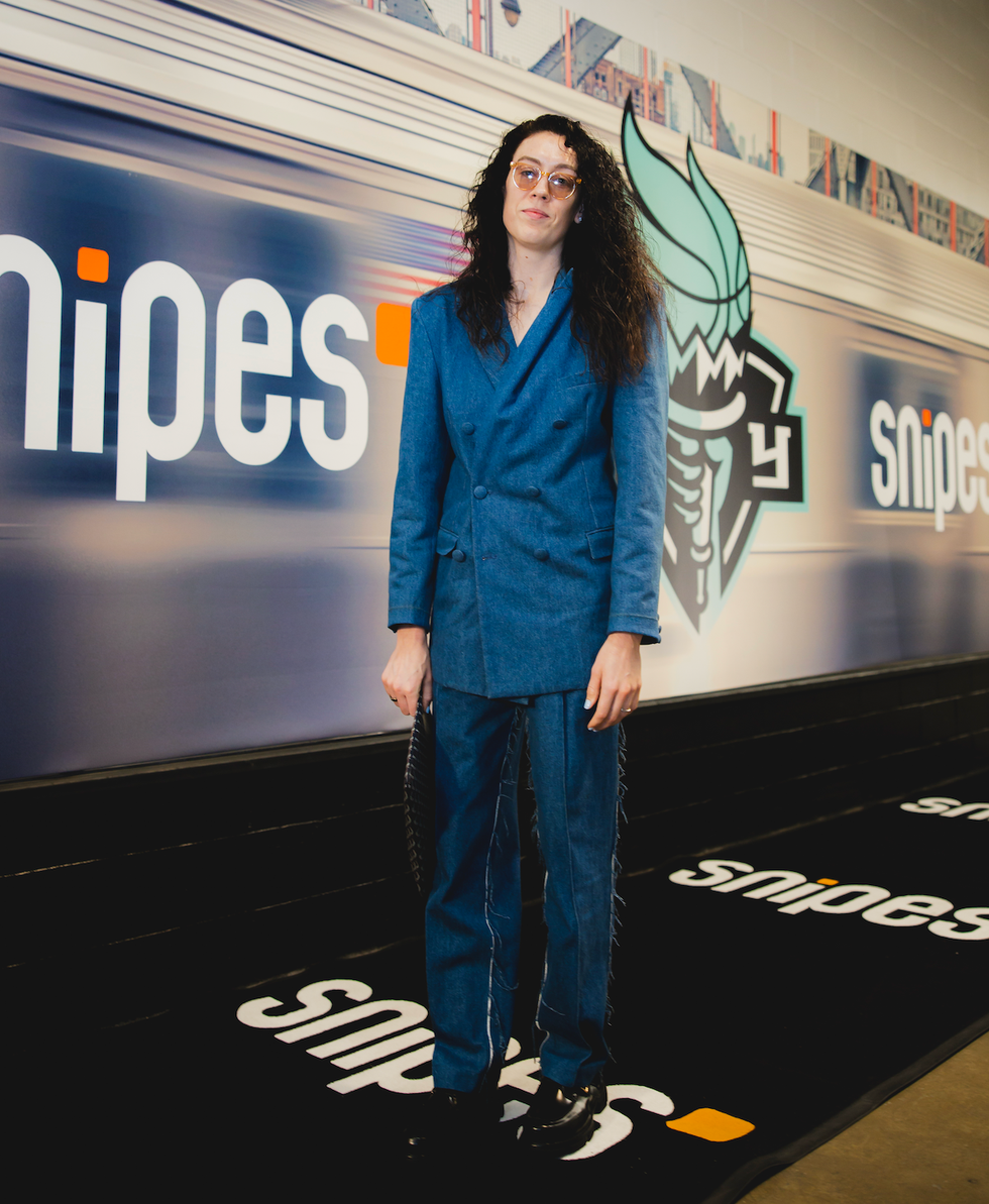 fashionable individual standing next to a snipes store backdrop
