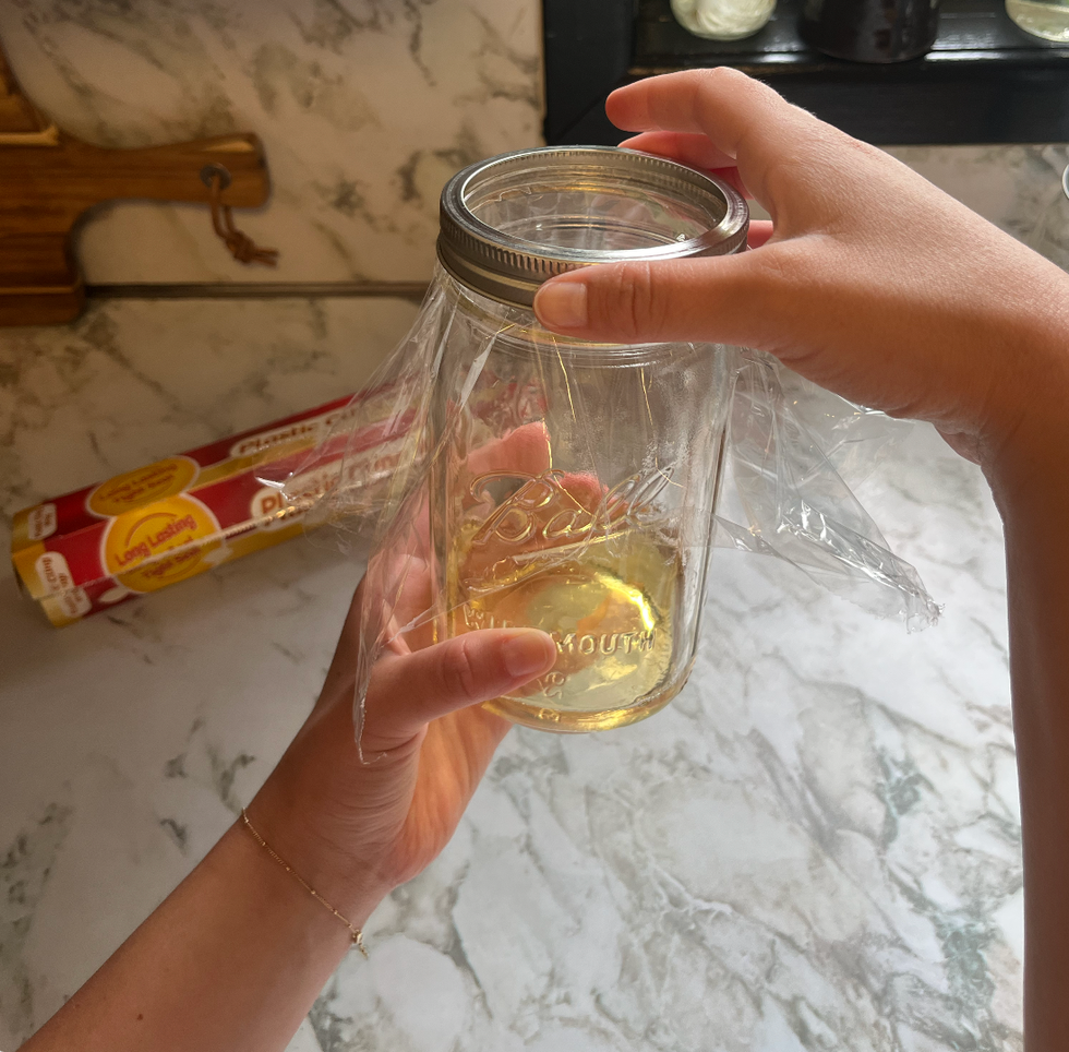 putting the lid on homemade fly trap made from a mason jar