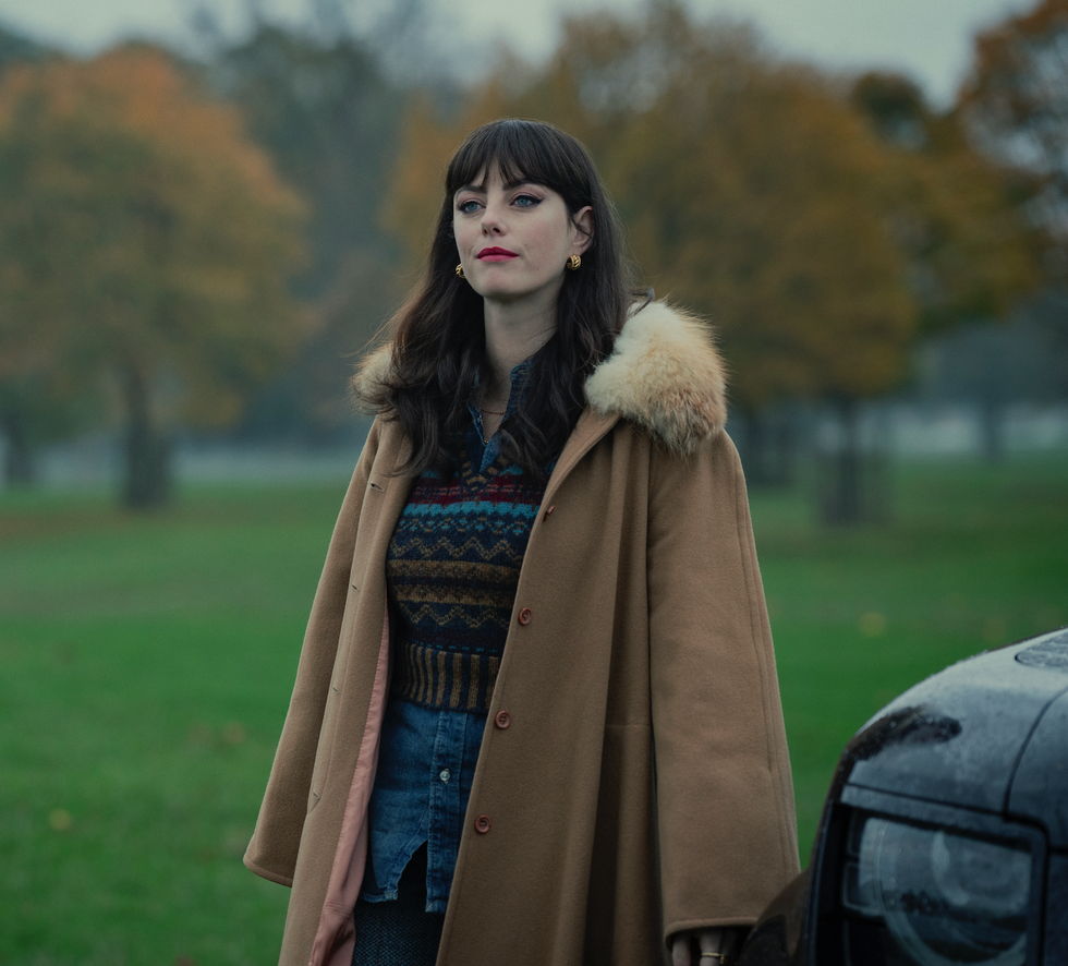 woman standing in a park wearing stylish outerwear