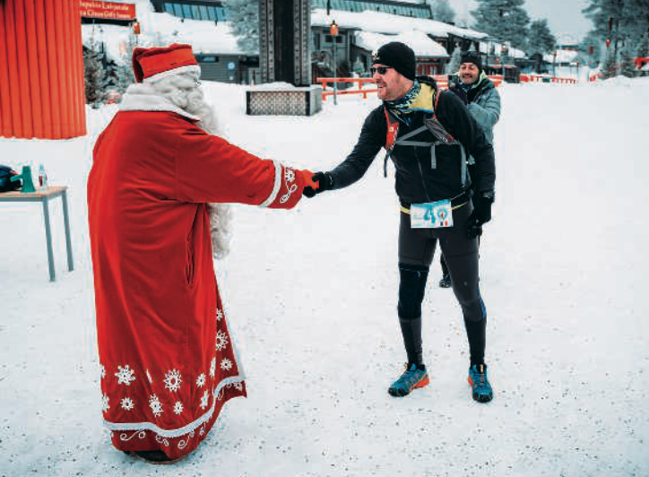 a festive figure greeting a runner in a snowy setting