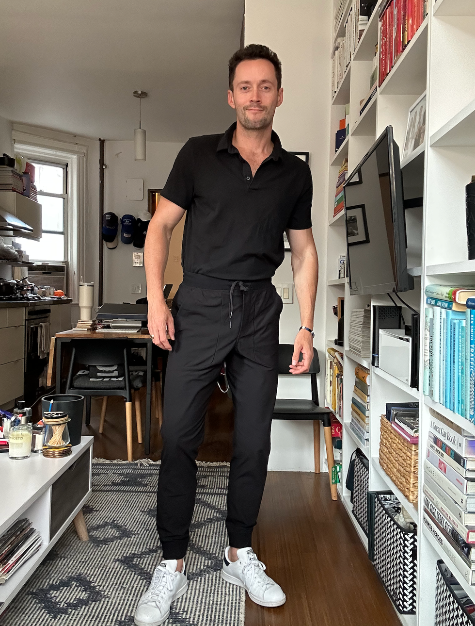 a person in casual attire stands in a modern living space