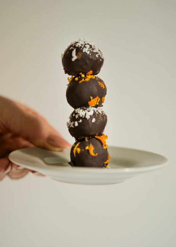 stack of four chocolatecovered dessert balls on a plate