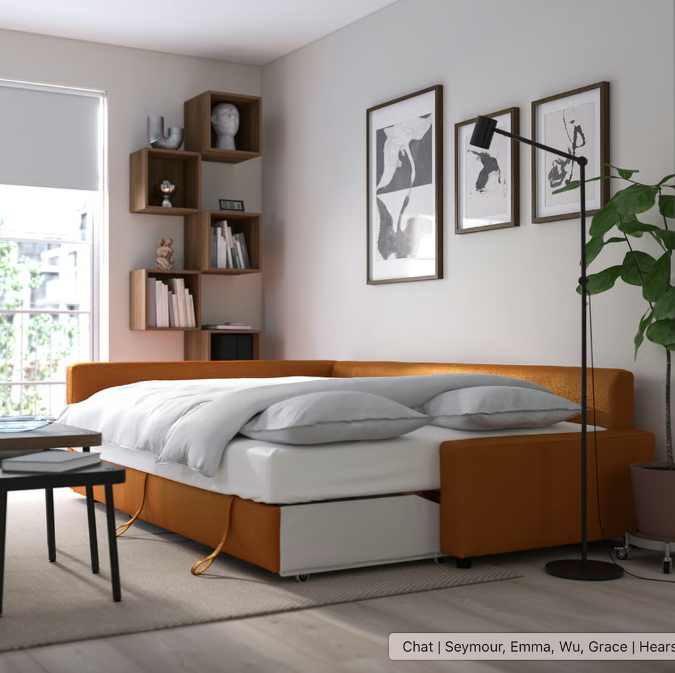 orange sleeper sofa from ikea extended into a bed in a living room setup