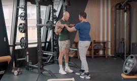 two individuals engaged in a weightlifting activity