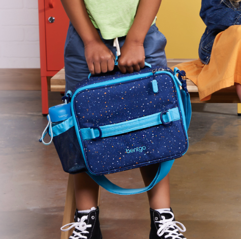 child holding a blue lunch tote