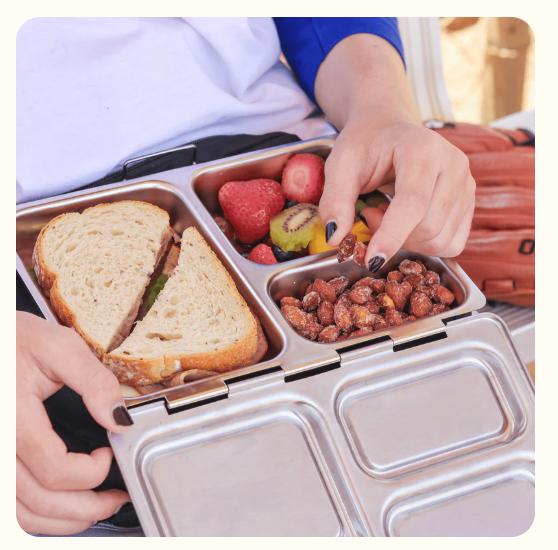 child chooses nuts from their planetbox lunch box