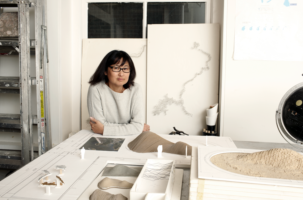 woman in front of architectural miniatures