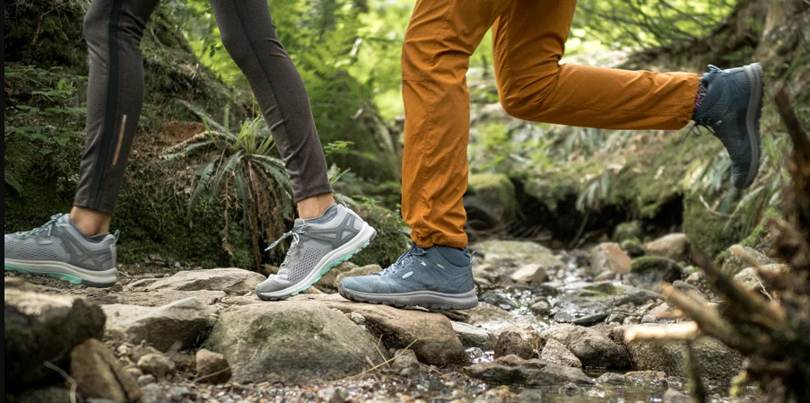 two individuals walking over rocky terrain wearing hiking footwear